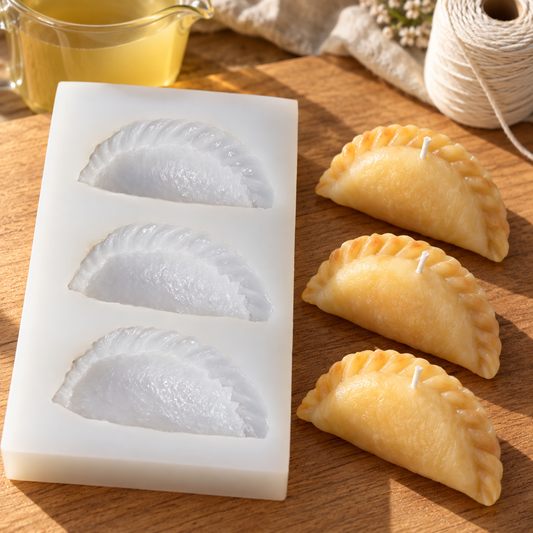Three-cavity silicone gujiya mould and example golden wax candles on a sunlit craft table