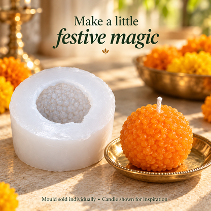 Orange motichoor laddu candle on brass saucer beside reusable silicone mould