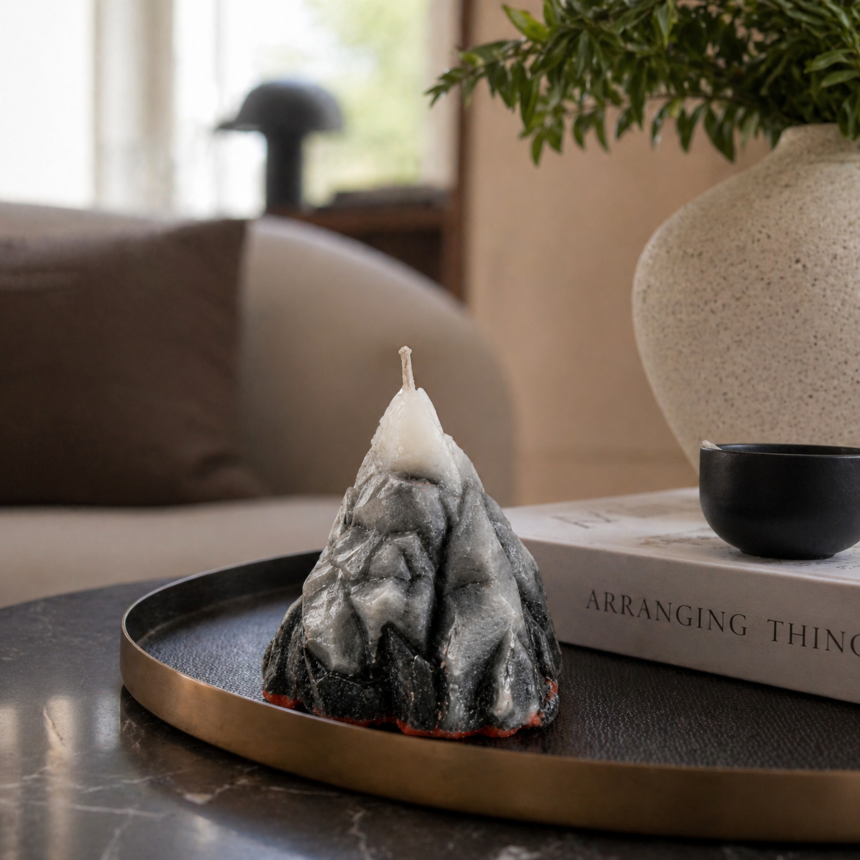 Mountain-shaped candle on a tray with a blurred indoor background